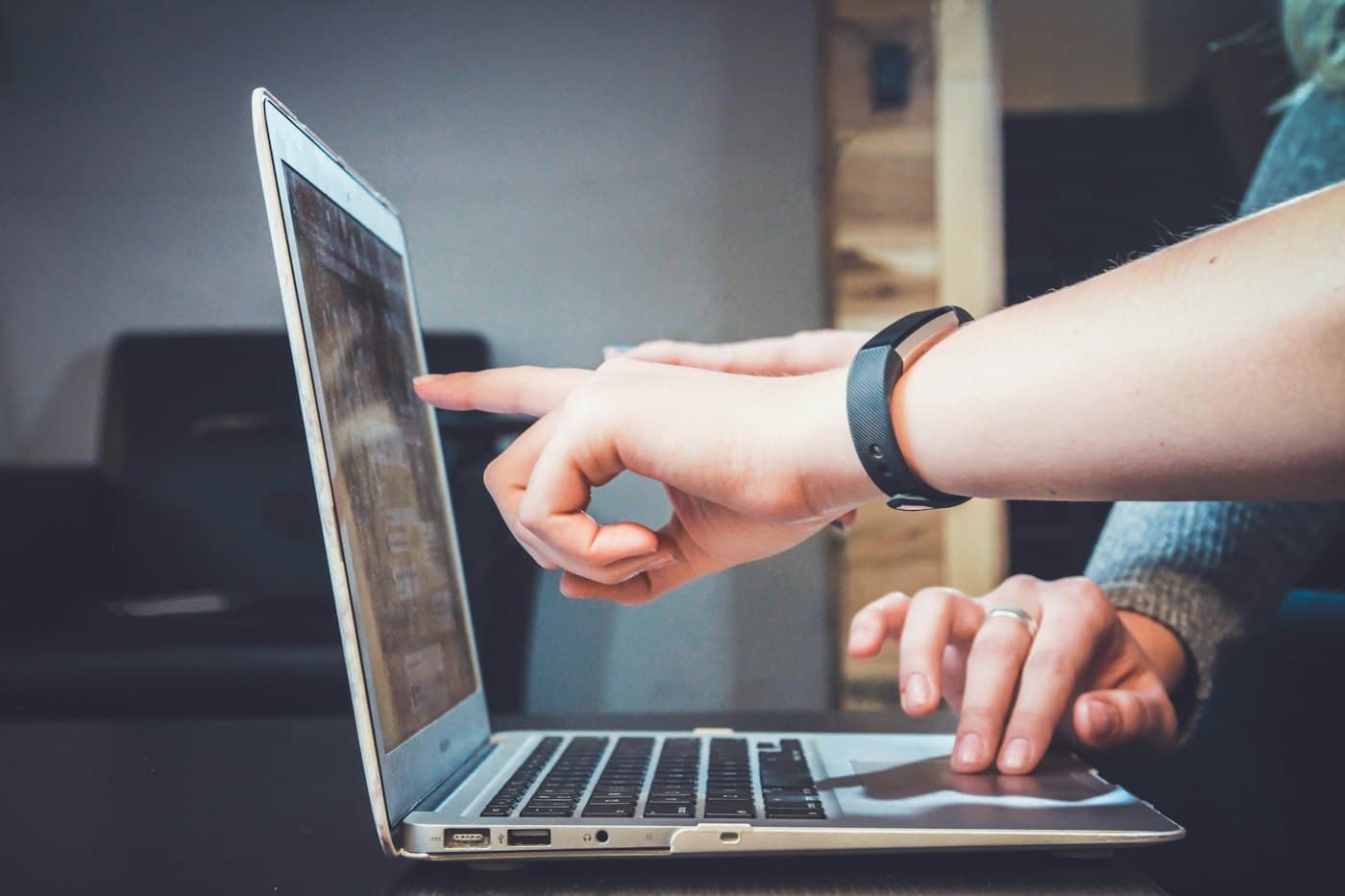 Hands typing on a laptop with data overlays